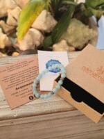 Bracciale con pietre naturali di Acquamarina e perle lavorate in argento 925 inserite nella parte alta del bracciale. Presente nella foto la sua confezione regalo in cartone ecologico con il logo Namamala e foglietto informativo.