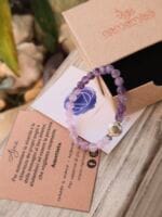 Bracciale con pietre naturali Ametista vicino di la sua confezione regalo in cartone ecologico con il logo Namamala e foglietto informativo.