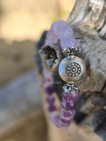 Dettaglio ravvicinato del bracciale Ajna, in ametista, con elemento centrale perla in argento Karen Tribe 97-99%. con uno sfondo naturale di legno.