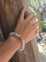 bracciale berillo donna indossato al polso di donna con la mano appoggiata a un tronco