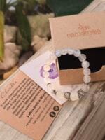 Bracciale con pietre naturali di Labradorite bianca in due forme e appoggiato sopra la sua confezione regalo in cartone ecologico con il logo Namamala e foglietto informativo.
