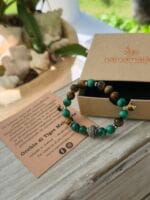 Bracciale con pietre naturali di malachite e occhio di tigre con la sua confezione regalo in cartone ecologico con il logo Namamala e foglietto informativo.