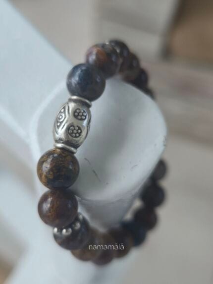 Dettaglio ravvicinato del bracciale Pietersite "Nuova Energia" in pietre naturali con elemento centrale perla a barile in argento Karen Tribe 97-99%.