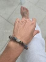 Bracciale da donna e da uomo con pietre naturali di Pietersite dalle sfumature blu e ocra e con elemento centrale in argento lavorato Karen Tribe indossato al polso.