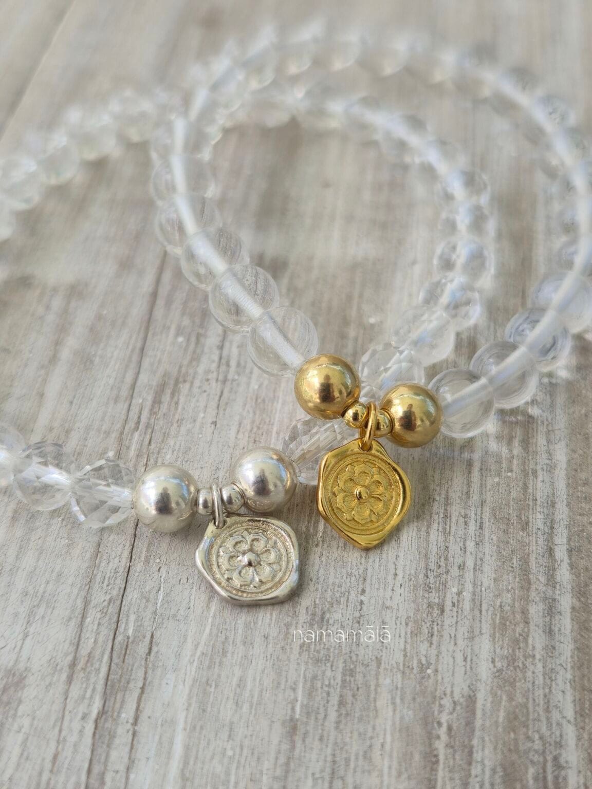 Set di bracciali in Quarzo Ialino trasparente con ciondoli a medaglietta in oro e argento raffiguranti il fiore di loto.