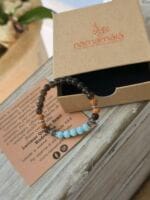 Bracciale con pietre naturali di quarzo fumè larimar rudraksha con la sua confezione regalo in cartone ecologico con il logo Namamala e foglietto informativo.