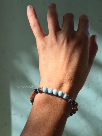 bracciale donna indossato al polso con pietre di larimar e quarzo fumè e semi di rudraksha