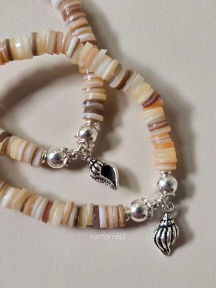 bracciale sapore di mare con perline di conchiglia e ciondolo a conchiglia mostrato in tutti e due i lati