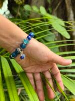 bracciale sfumature di blu con apatite blu larimar calcedonio blu cianite blue lapislazzuli indossato su sfondo di foglie verdi