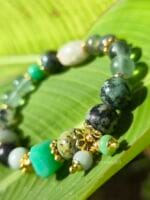 bracciale elastico sfumature di verde con crisoprasio turchese africano giada verde prehnite fluorite verde e dettagli dorati appoggiato ad una foglia verde