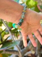 bracciale elastico sfumature di verde con crisoprasio turchese africano giada verde prehnite fluorite verde e dettagli dorati indossato al polso
