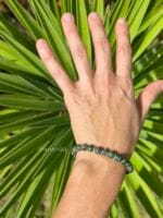 Dettaglio gioiello Namamālā: bracciale elastico con pietre naturali di Turchese Africano e inserti in argento 925 decorati per donna e indossato al polso.