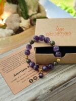 Bracciale con pietre naturali di ametista pirite insieme alla sua confezione regalo in cartone ecologico con il logo Namamala e foglietto informativo.