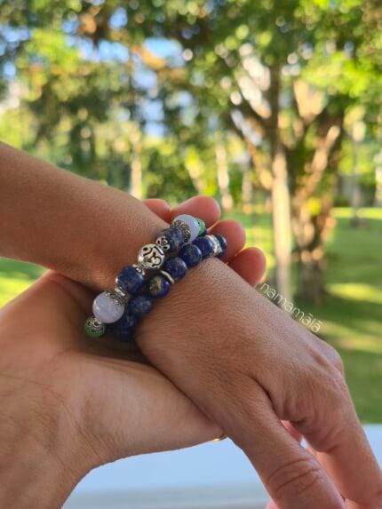 Bracciali yoga da uomo e da donna con pietre naturali di Lapislazzuli e lapislazzuli calcedonio blu e crisoprasio con distanziatori in argento 925, indossati al polso con un contesto di natura e foglie verdi illuminate dal sole.