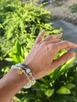 Bracciali da donna con pietre naturali di Quarzo ialino e distanziatori in argento 925, indossati al polso con un contesto di natura e foglie verdi illuminate dal sole.